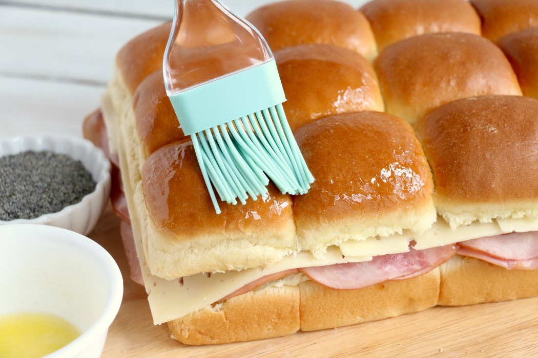 Ham and Cheese Sliders -Hawaiian rolls filled with ham, cheese, onions and a delicious mustard sauce, then brushed with butter. A great appetizer to feed a crowd!
