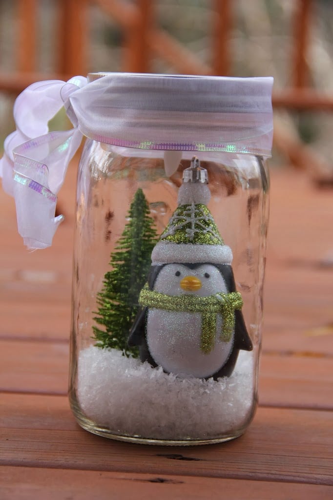 Beautifully decorated DIY mason jar Christmas crafts with festive holiday ornaments and fairy lights.