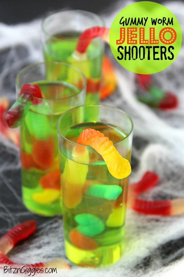 Gummy Worm Jello Shooters - A fun kids treat perfect for mad scientist parties and Halloween! Gummy worms are suspended in green jello and the treat is garnished with a full size worm "crawling" out of the glass!