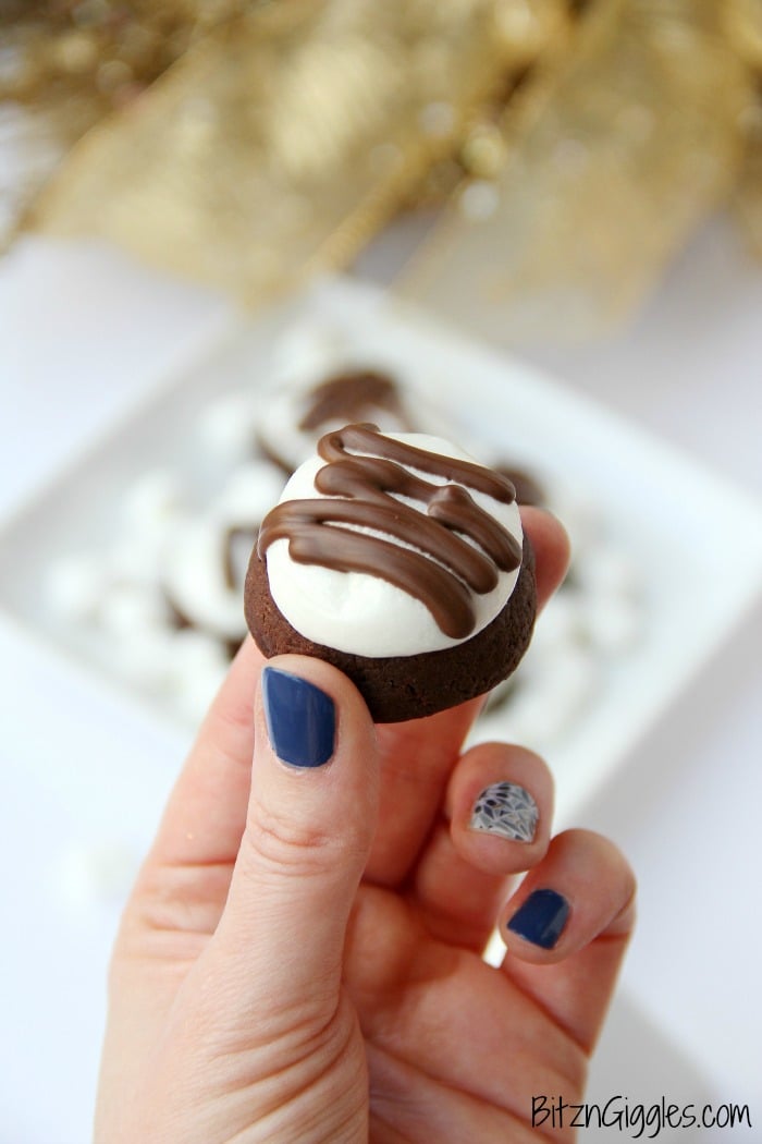 Surprise Inside Marshmallow Brownie Bites - Bite-sized brownie cookies filled with a caramel center and topped with marshmallow and chocolate drizzle!