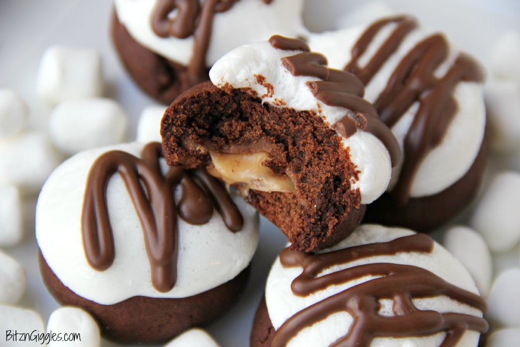 Surprise Inside Marshmallow Brownie Bites - Bite-sized brownie cookies filled with a caramel center and topped with marshmallow and chocolate drizzle!