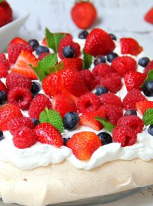 Triple Berry Pavlova - This meringue cake is crisp on the outside and soft and light on the inside! Topped with homemade whipped cream and fresh berries, it's such an elegant, light and delicious dessert!