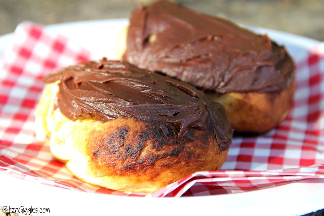 Easy Campfire Eclairs - Crescent roll dough wrapped around roasting forks, browned over the campfire, then filled with pudding and topped with chocolate frosting! Such a great camping treat!