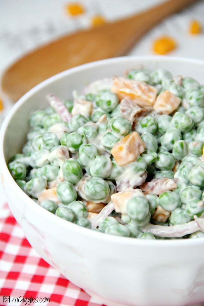 Easy Pea Salad - A summer salad perfect for potlucks and gatherings. Crisp green peas float alongside bacon, cheddar cheese and thinly sliced red onion in a sweet and creamy dressing.