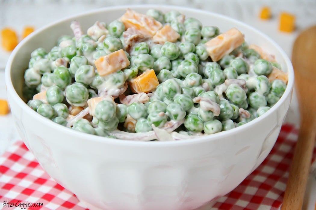 Easy Pea Salad - A summer salad perfect for potlucks and gatherings. Crisp green peas float alongside bacon, cheddar cheese and thinly sliced red onion in a sweet and creamy dressing.