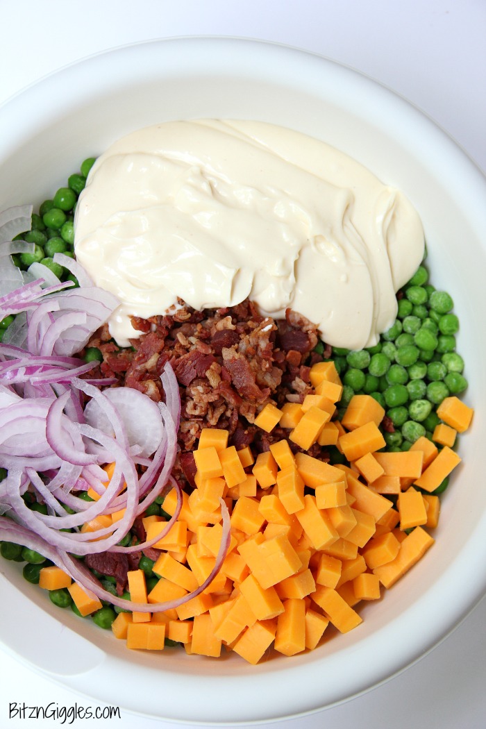 Easy Pea Salad - A summer salad perfect for potlucks and gatherings. Crisp green peas float alongside bacon, cheddar cheese and thinly sliced red onion in a sweet and creamy dressing.