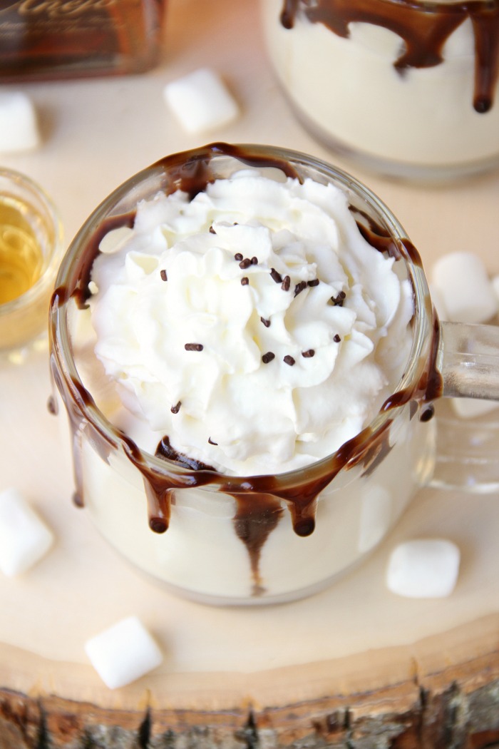 Rum & White Chocolate Hot Cocoa - a heavenly combination of white chocolate, rum, marshmallows, drizzles of chocolate and a big swirl of whipped cream topped with sprinkles is the ultimate fall indulgence!