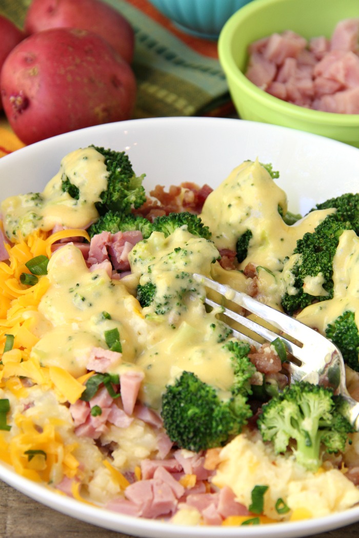 Twice Baked Potato Bowl - Baby reds are steamed, mashed, loaded with delicious toppings and then drizzled with a cheesy broccoli sauce. Tastes just like a twice baked potato but prepared in record time!