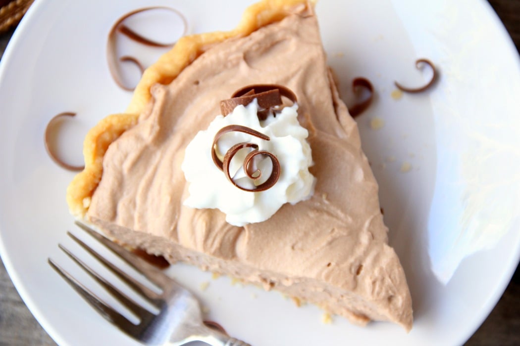 Mile High Chocolate Mousse Pie - Creamy, decadent chocolate mousse piled high and finished off with whipped cream and chocolate shavings.