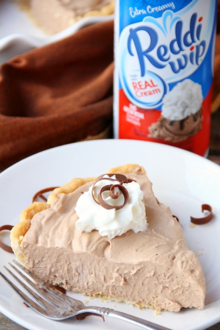 Mile High Chocolate Mousse Pie - Creamy, decadent chocolate mousse piled high and finished off with whipped cream and chocolate shavings.