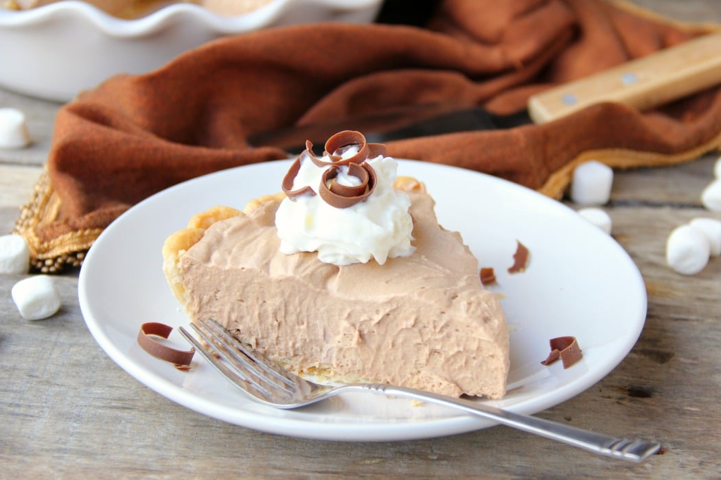 Mile High Chocolate Mousse Pie - Creamy, decadent chocolate mousse piled high and finished off with whipped cream and chocolate shavings.