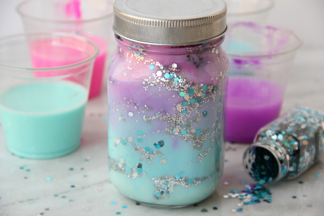 DIY Galaxy Jar -A gorgeous craft for kids, teens or even adults who love color and glitter! Simply layer cotton balls, acrylic paint, water and glitter shapes to create your own galaxy in a jar!