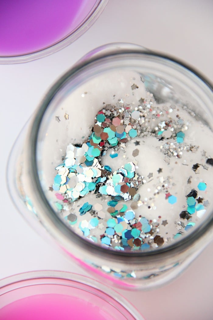 DIY Galaxy Jar -A gorgeous craft for kids, teens or even adults who love color and glitter! Simply layer cotton balls, acrylic paint, water and glitter shapes to create your own galaxy in a jar!