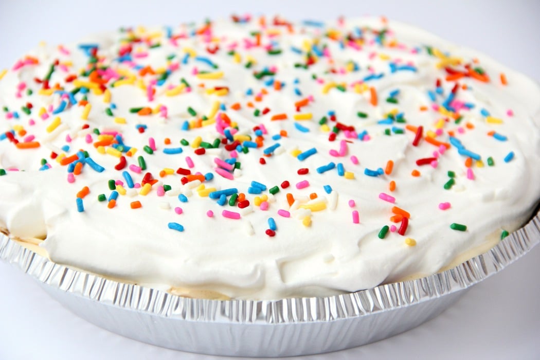 Ultimate Ice Cream Sundae Pie - Fudge and caramel topping filled ice cream pie with a fluffy whipped topping covered in sprinkles!