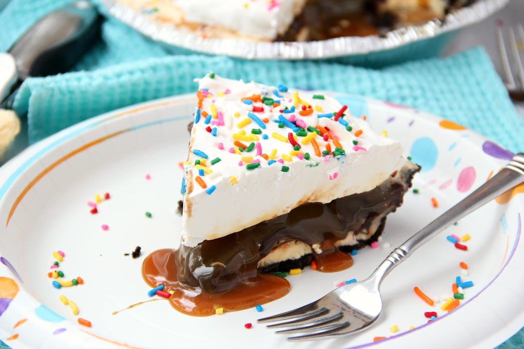 Ultimate Ice Cream Sundae Pie - Fudge and caramel topping filled ice cream pie with a fluffy whipped topping covered in sprinkles!