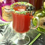 Spooky Halloween Punch - This Halloween punch is only three ingredients! When served in a nonpareil-rimmed glass, the color of the candy starts dripping eerily into the punch, creating fun black streaks and darkening the color of the drink!