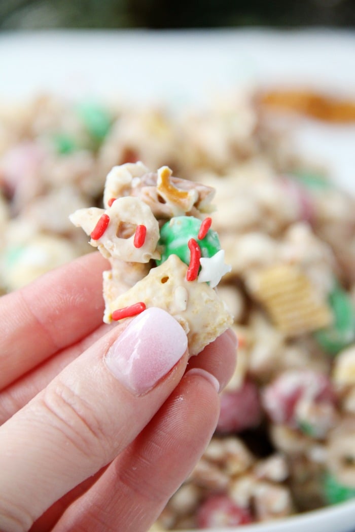 Easy Reindeer Chow - A delicious snack mix filled with pretzels, peanuts, Cheerios, Chex and M&Ms covered in white chocolate. Great for snacking and gift giving!