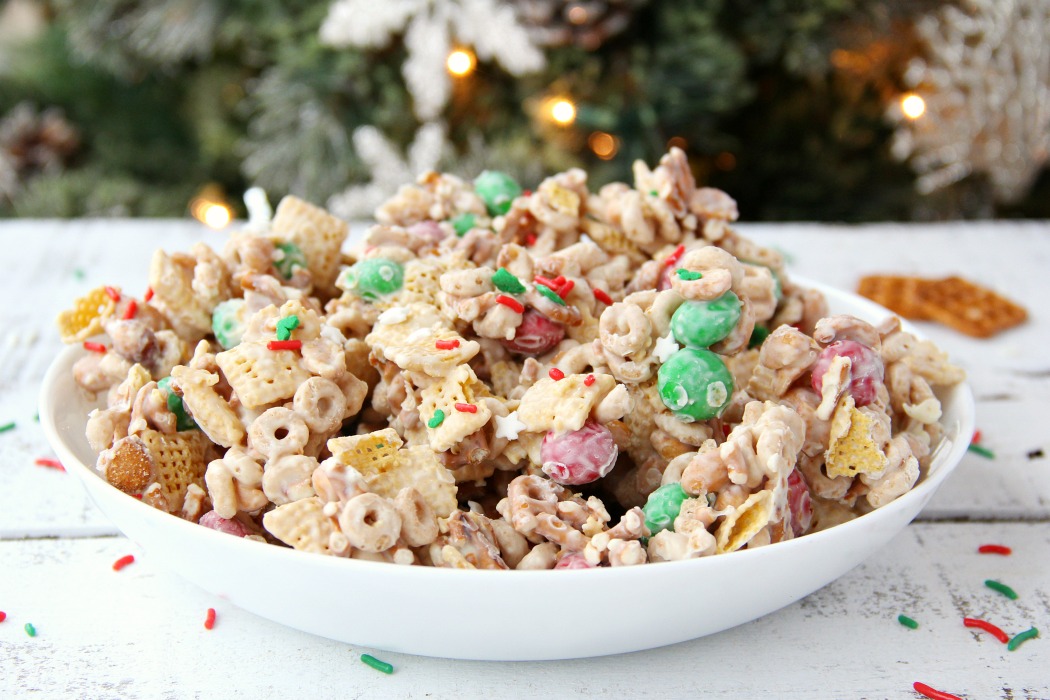 Easy Reindeer Chow - A delicious snack mix filled with pretzels, peanuts, Cheerios, Chex and M&Ms covered in white chocolate. Great for snacking and gift giving!