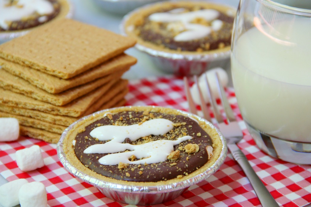 No-Bake S'mores Tarts - A delicious spin on the traditional s'more. These 5-ingredient mini pies are filled with marshmallow creme, chocolate and peanut butter. The perfect end to a summer BBQ!