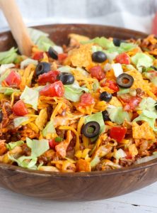 Dorito Taco Salad - This crunchy and zesty salad is made with seasoned ground beef, veggies, cheese and Doritos, then tossed with Catalina dressing. So delicious and serves a crowd!