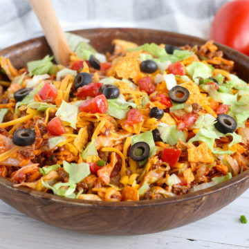 Dorito Taco Salad - This crunchy and zesty salad is made with seasoned ground beef, veggies, cheese and Doritos, then tossed with Catalina dressing. So delicious and serves a crowd!