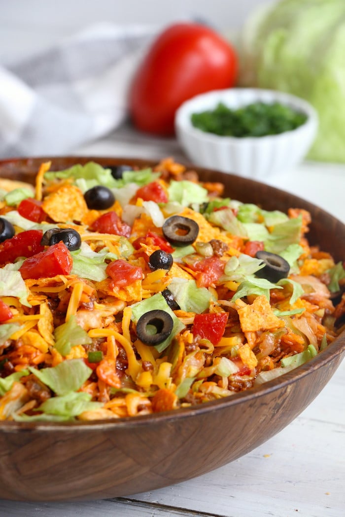 Dorito Taco Salad - This crunchy and zesty salad is made with seasoned ground beef, veggies, cheese and Doritos, then tossed with Catalina dressing. So delicious and serves a crowd!