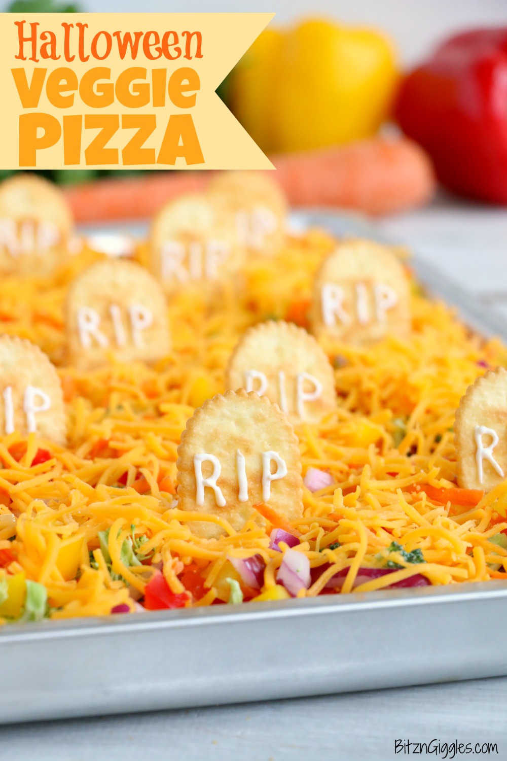 Halloween Veggie Pizza - A spooky themed graveyard pizza featuring a flavorful ranch cream cheese covered crust, topped with colorful veggies and "tombstone" crackers. 