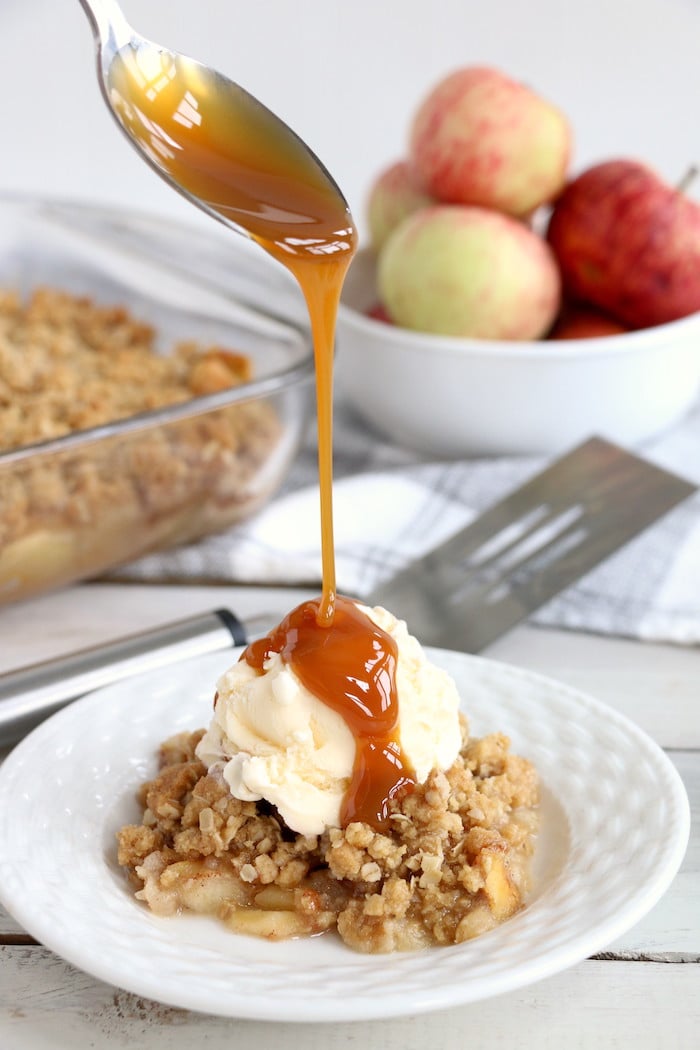 Easy Apple Crisp - A delicious, old-fashioned crisp made with sliced apples and a crunchy brown sugar oat topping. A scoop of vanilla ice cream and salted caramel sauce puts it over the top!