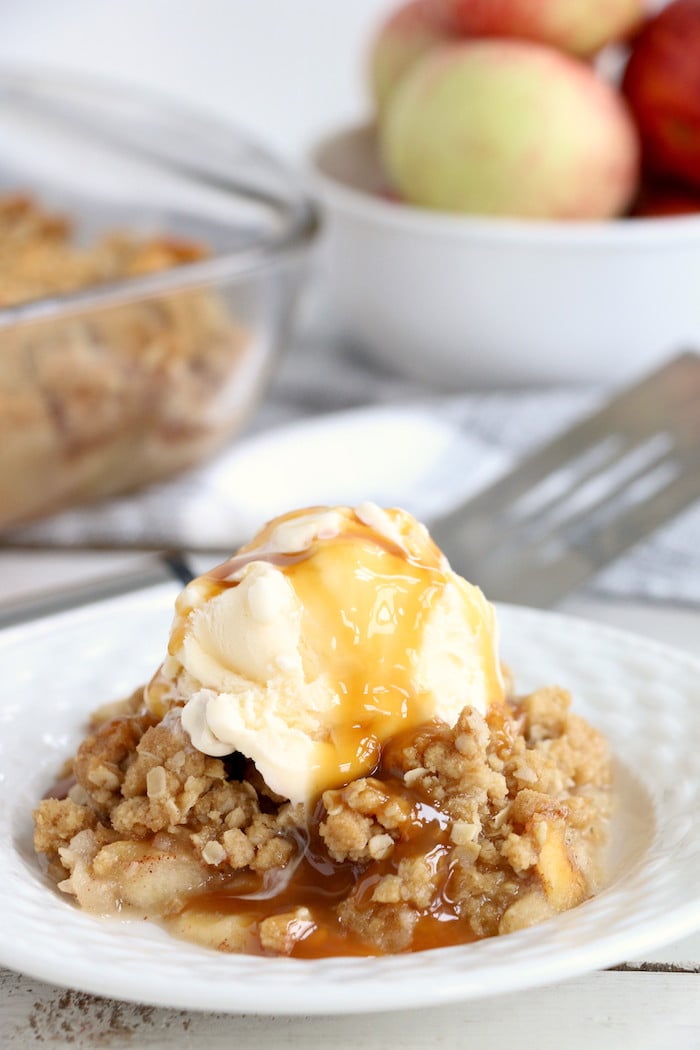 Easy Apple Crisp - A delicious, old-fashioned crisp made with sliced apples and a crunchy brown sugar oat topping. A scoop of vanilla ice cream and salted caramel sauce puts it over the top!