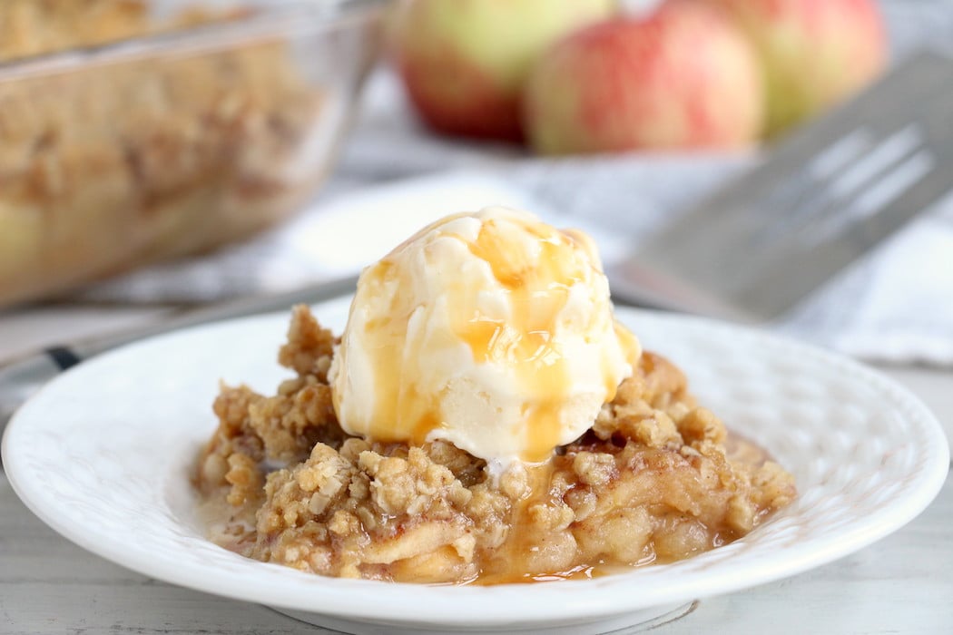 Easy Apple Crisp - A delicious, old-fashioned crisp made with sliced apples and a crunchy brown sugar oat topping. A scoop of vanilla ice cream and salted caramel sauce puts it over the top!