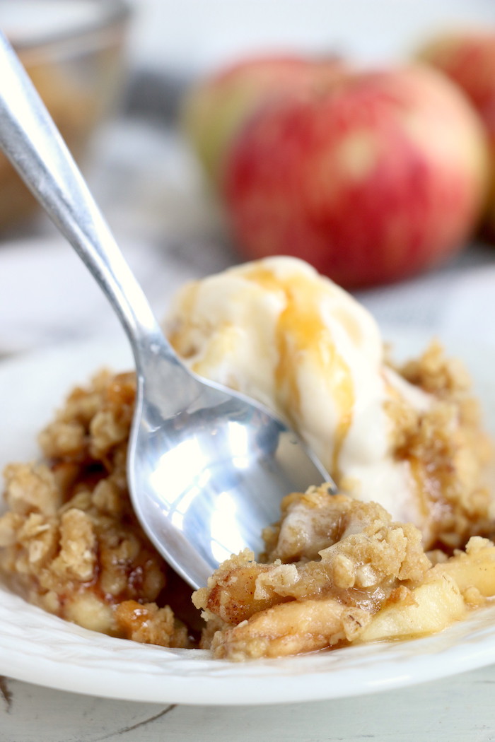 Easy Apple Crisp - A delicious, old-fashioned crisp made with sliced apples and a crunchy brown sugar oat topping. A scoop of vanilla ice cream and salted caramel sauce puts it over the top!