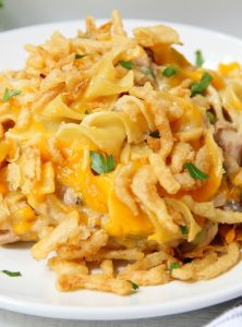 Classic Tuna Noodle Casserole - Ready in under 45 minutes, this classic and comforting casserole features tuna, onions, mushrooms, peas and cheese in a creamy sauce topped with more cheese and crunchy French fried onions! So flavorful, and sure to satisfy the entire family!