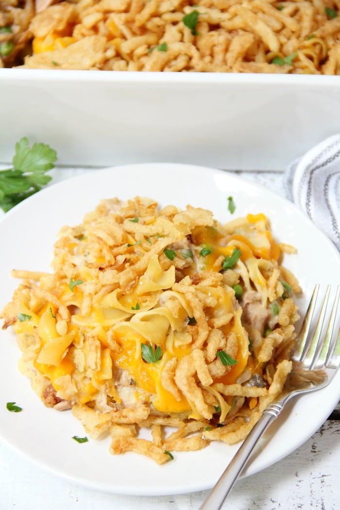 Classic Tuna Noodle Casserole - Ready in under 45 minutes, this classic and comforting casserole features tuna, onions, mushrooms, peas and cheese in a creamy sauce topped with more cheese and crunchy French fried onions! So flavorful, and sure to satisfy the entire family! 