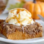 Pumpkin Dump Cake - An easy and delicious pumpkin spice cake topped with vanilla ice cream and caramel drizzle!