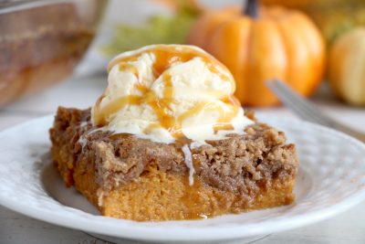 Pumpkin Dump Cake - An easy and delicious pumpkin spice cake topped with vanilla ice cream and caramel drizzle!