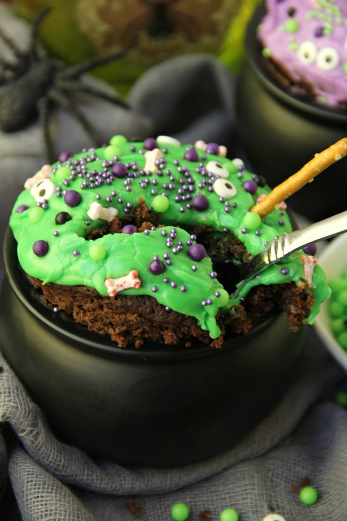 Witch Cauldron Mug Cake - A chocolate mug cake made in a ceramic witch cauldron with halloween-themed frosting and sprinkles! 