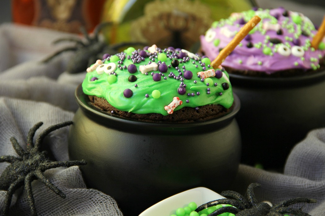 Witch Cauldron Mug Cake - A chocolate mug cake made in a ceramic witch cauldron with halloween-themed frosting and sprinkles!