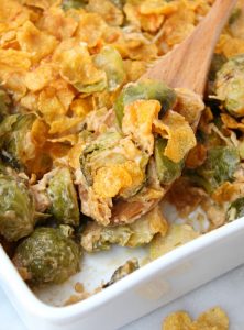 Scooping out brussels sprouts from casserole dish