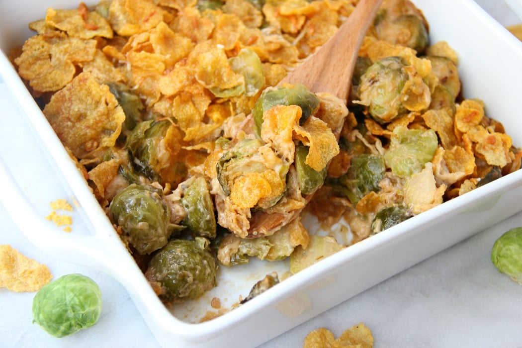 Scooping out brussels sprouts from casserole dish