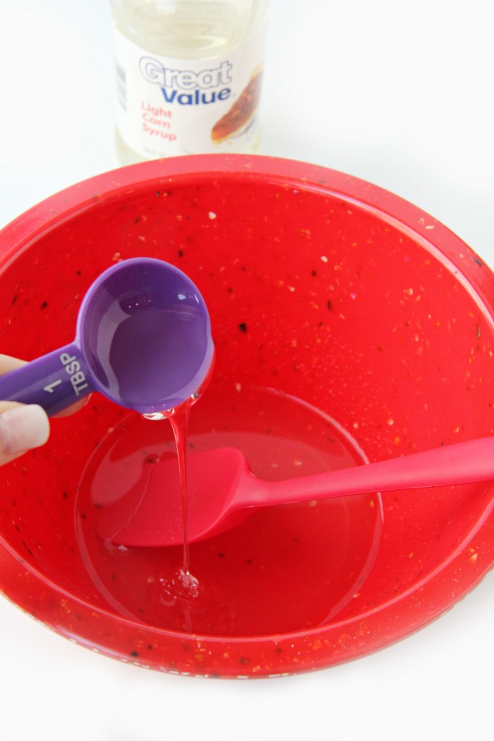 Adding corn syrup to red mixing bowl
