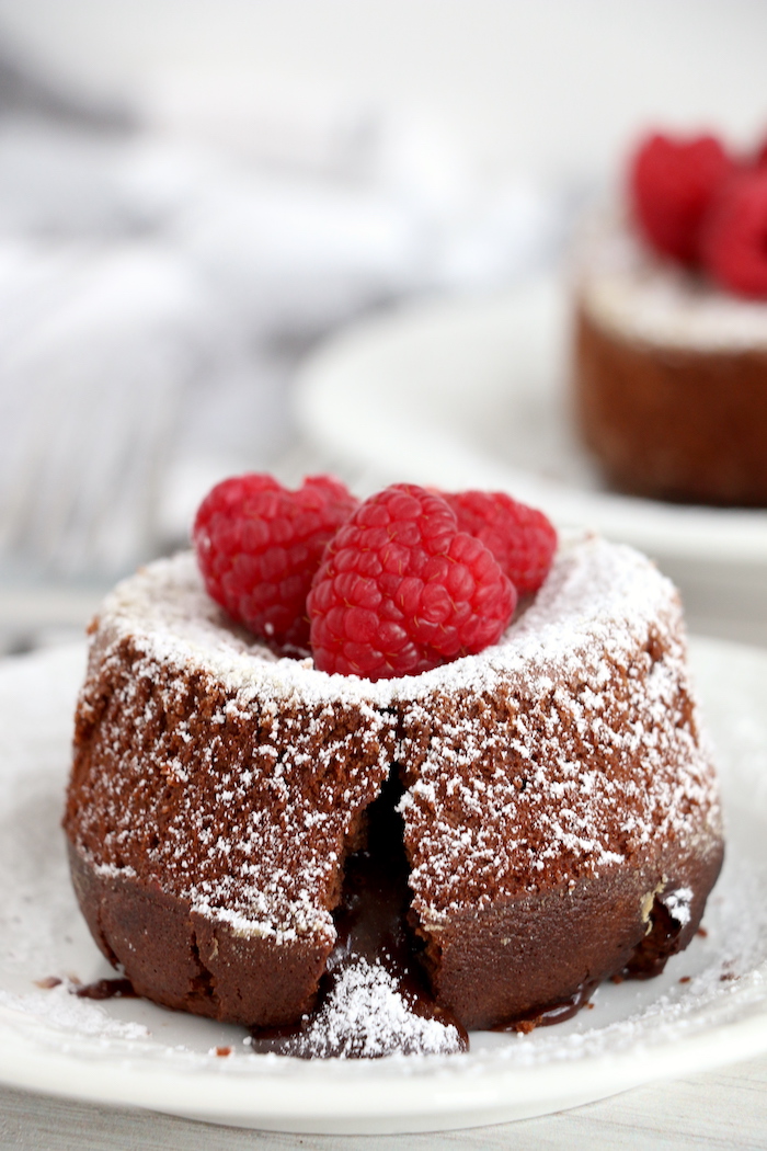 molten lava cake covered in powdered sugar and raspberries