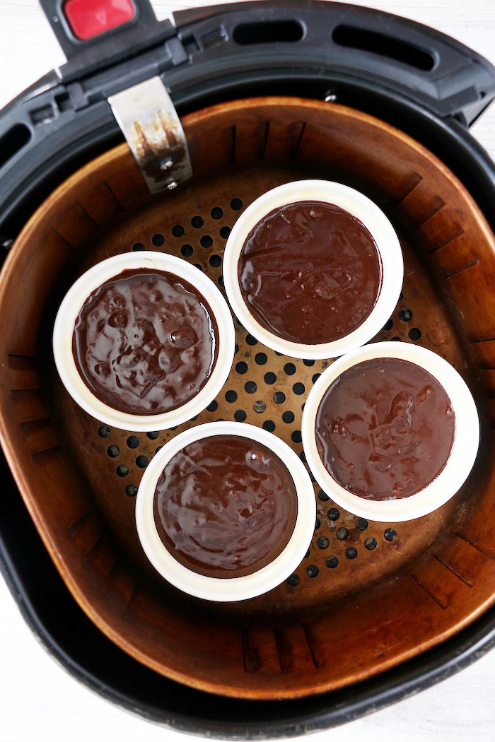 ramekins filled with chocolate batter in air fryer basket
