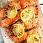 Salmon on a cutting board with lemon slices