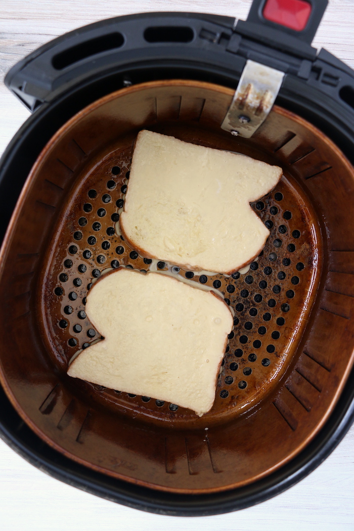 Pieces of brioche bread in air fryer basket