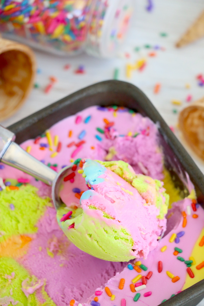 Scooping rainbow ice cream from a loaf pan