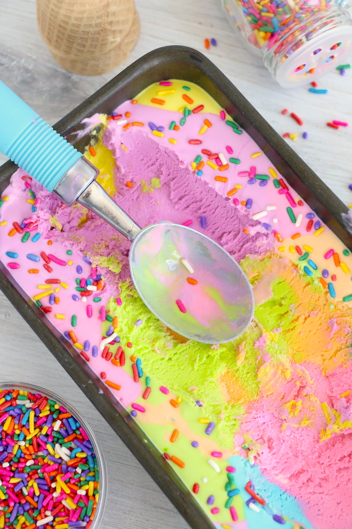 Ice cream scoop on top of rainbow ice cream in loaf pan