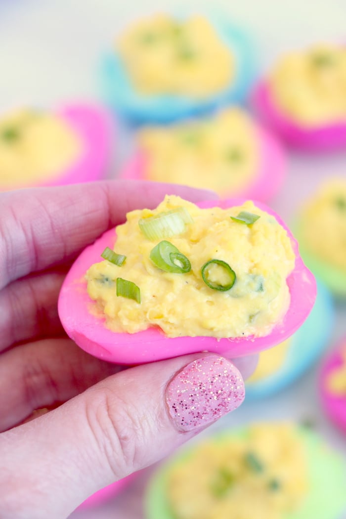 holding a pink deviled egg