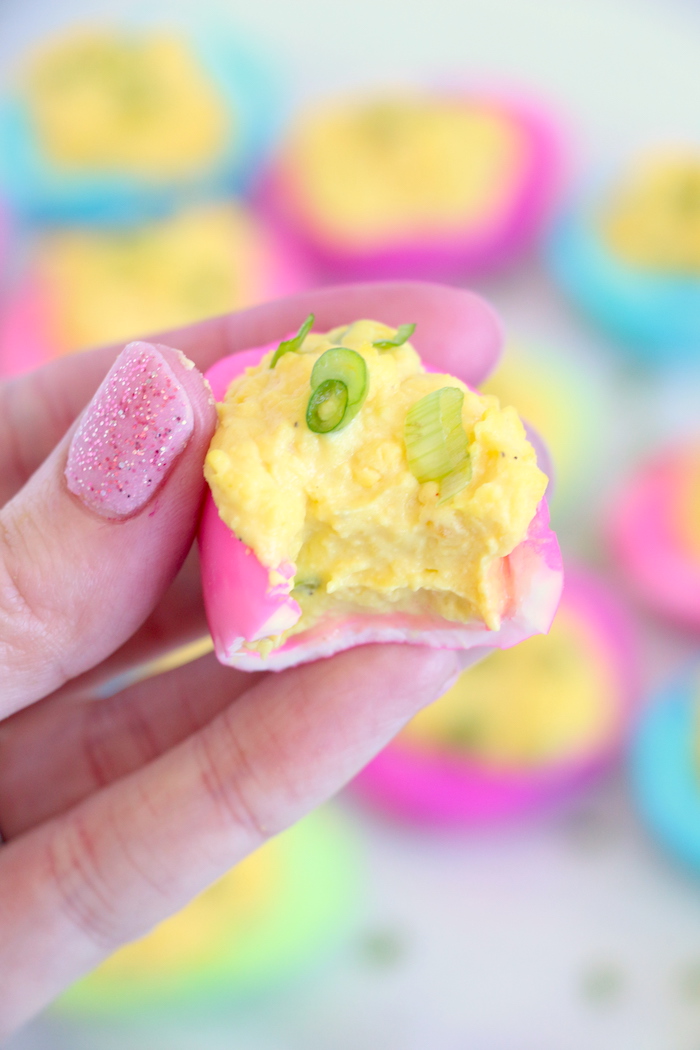 a bite out of a colorful deviled egg