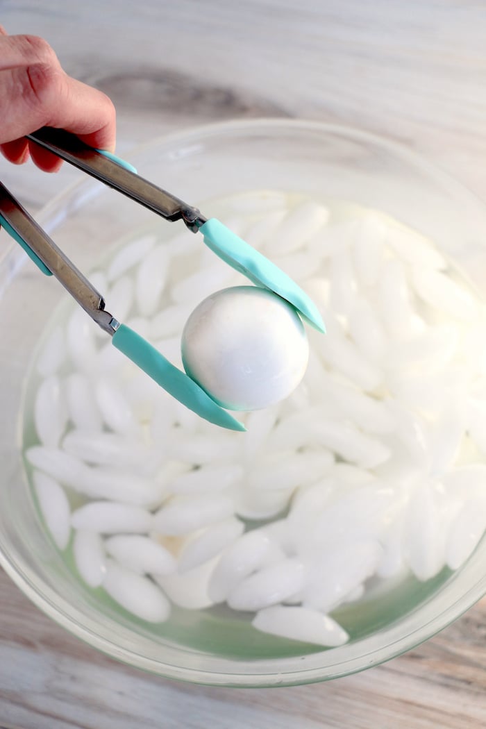 Placing an egg in an ice water bath