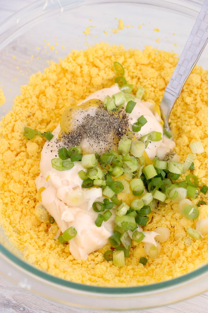 Mixing filling for deviled eggs in bowl